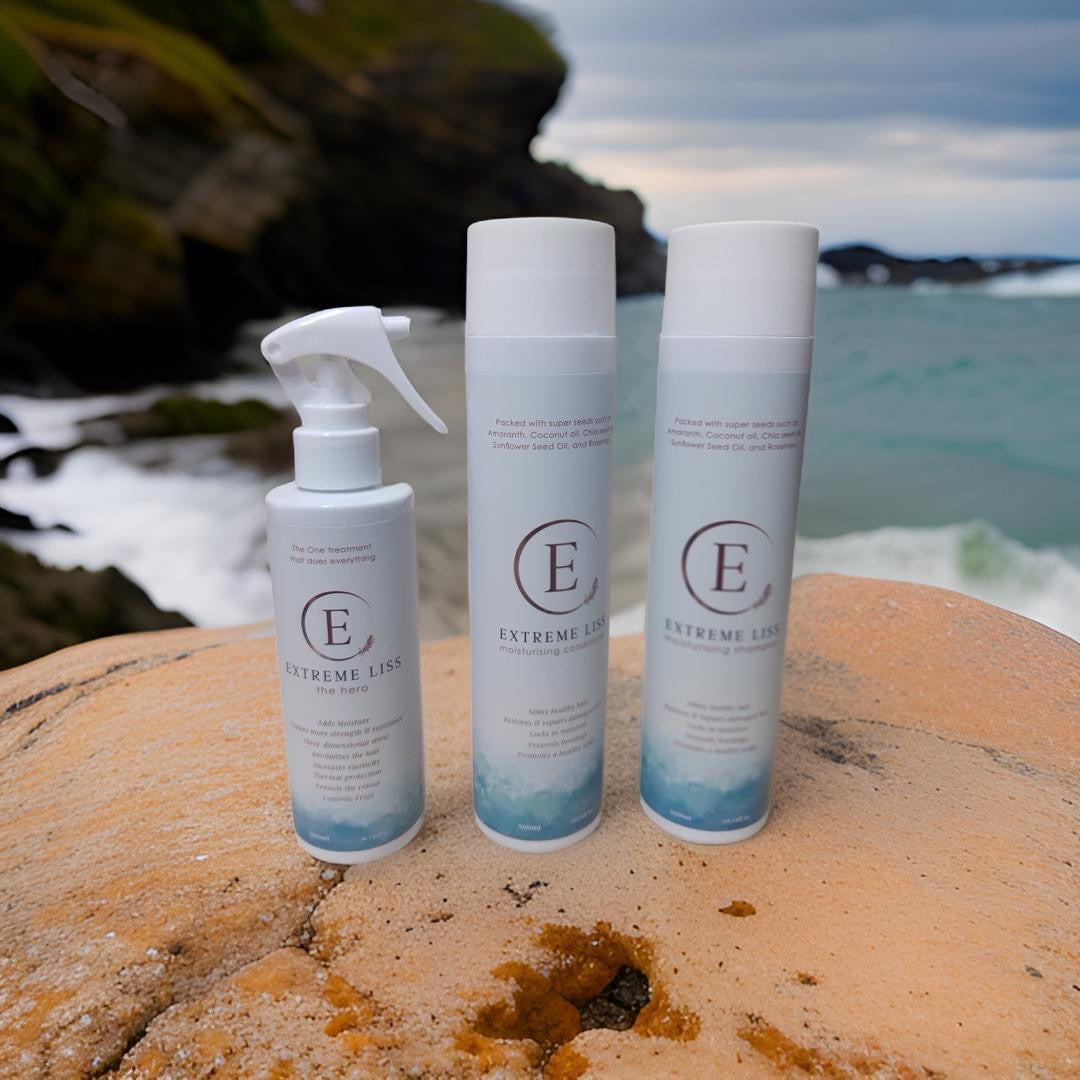 Extreme Liss The Hero 200ml, Moisturising Conditioner 300ml and Moisturising Shampoo 300ml on a beach rock